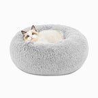 Cat resting in a soft grey donut pet bed