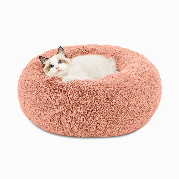 Cat resting in a pink faux-fur donut pet bed