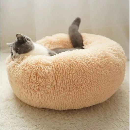 Cat resting in a peach faux-fur donut pet bed